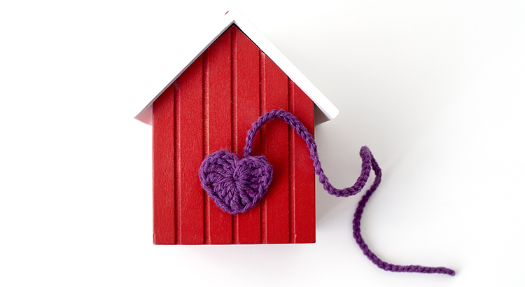 Home is where the heart is. Elevated view of the wooden house with my wool heart