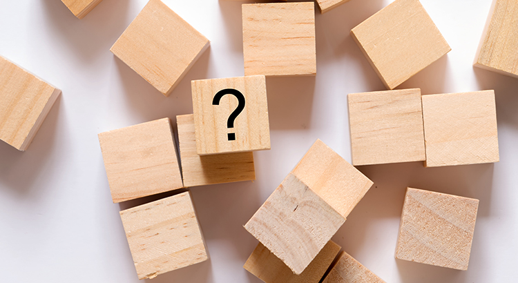 Directly above shot of wooden block with question mark written