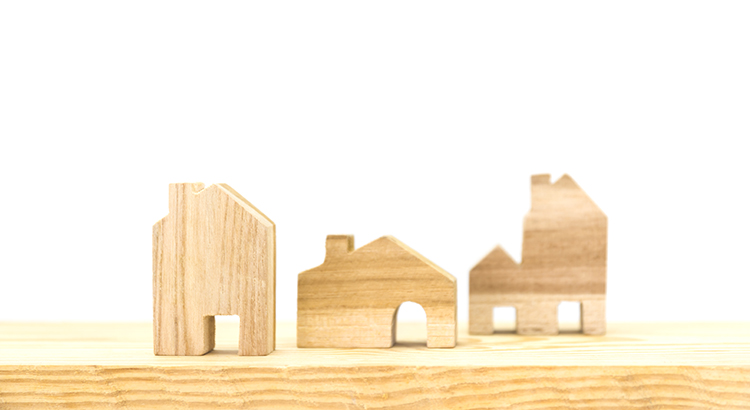 Wood house model on wood table over white wall background with copy space,Concept of real estate business.