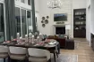 Highland Homes Furst Ranch Flower Mound TX kitchen with vaulted ceiling, wood beams, large island, and dark cabinetry.