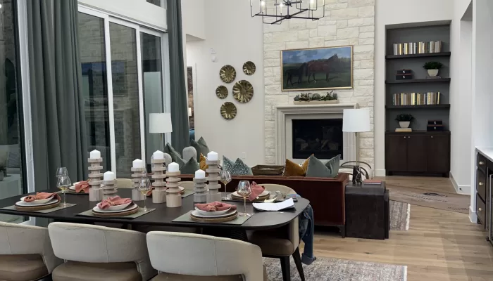 Highland Homes Furst Ranch Flower Mound TX kitchen with vaulted ceiling, wood beams, large island, and dark cabinetry.