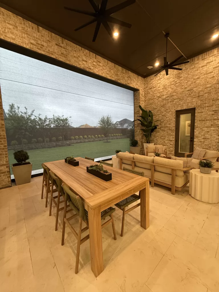 Highland Homes Furst Ranch covered patio with outdoor seating, ceiling fans, brick wall, and landscaped backyard.