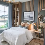 Guest bedroom in a David Weekley Homes model at Furst Ranch, featuring designer accent wall, built-in shelving, and modern lighting near Flower Mound and Bartonville, TX.